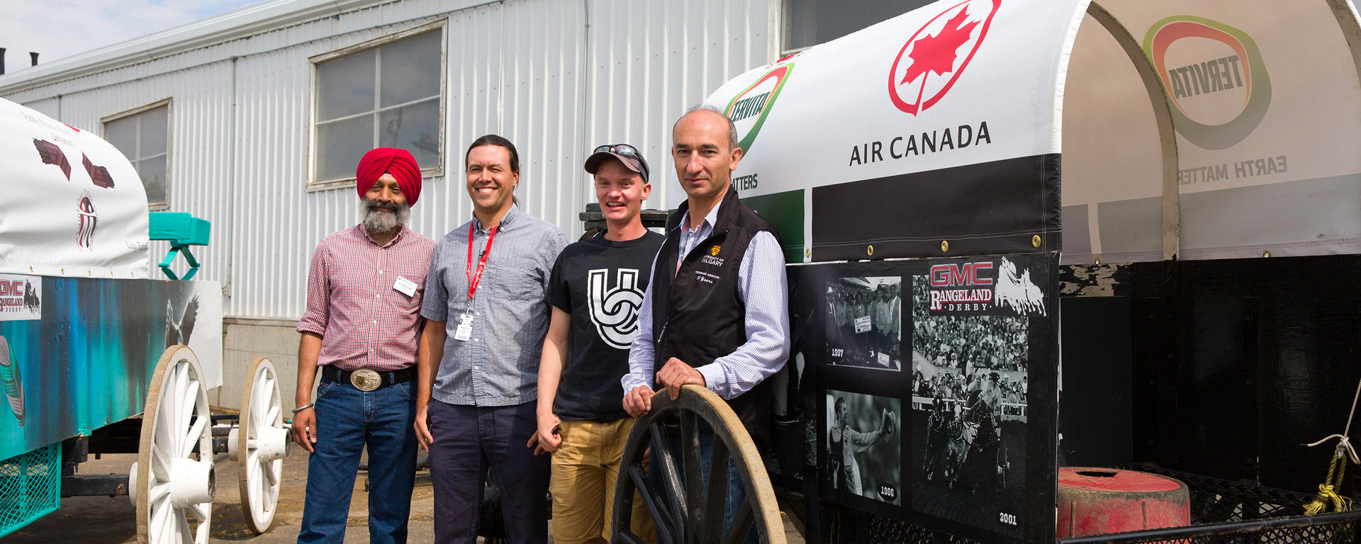 Baljit Singh, dean of the Faculty of Veterinary Medicine at the University of Calgary, meets behind the chuckwagon barns at the Calgary Stampede with professor Mark Ungrin, engineering student Sam Pollock and Renaud Leguillette. Photo by Riley Brandt, University of Calgary