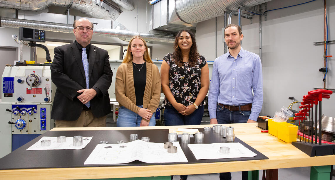Dr. Robert Thompson and Dr. Timothy Friesen with graduate student Pooja Woosaree and summer student Abby Swadling in the machine shop at the University of Calgary. 