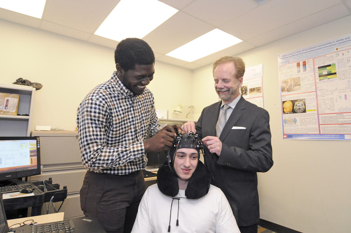 University of Calgary researchers have developed a brain imaging system that may one day be used in concussion treatment clinics and sports facilities to detect and monitor damage in the brain from concussion. From left, Ibukunoluwa Oni, graduate student with the Experimental Imaging Centre; Carter Randall, undergraduate research assistant; and Jeff Dunn, PhD, director of the Experiment Imaging Centre at the Cumming School of Medicine. Photos by Pauline Zulueta, Cumming School of Medicine