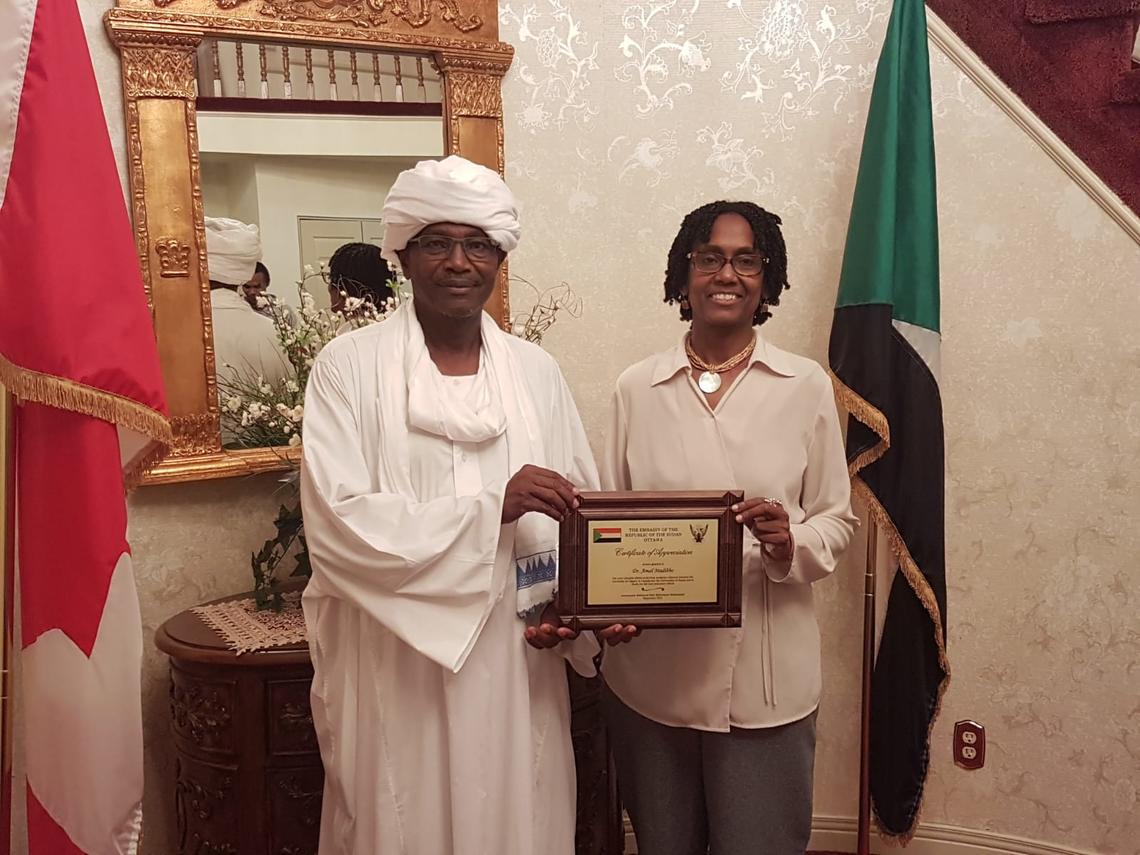 Sociology professor Amal Madibbo accepts Award of Recognition from the Ambassador of Sudan to Canada, Mahmoud Fadl.