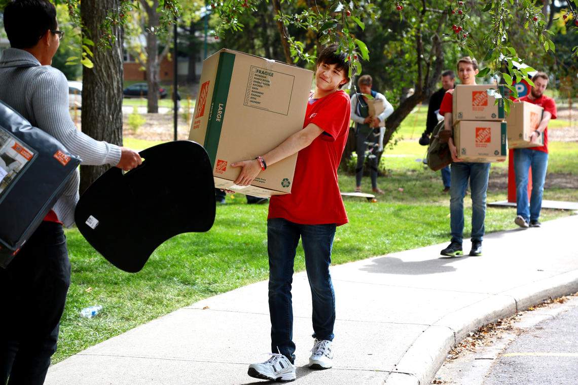 Students carry boxes on move-in day