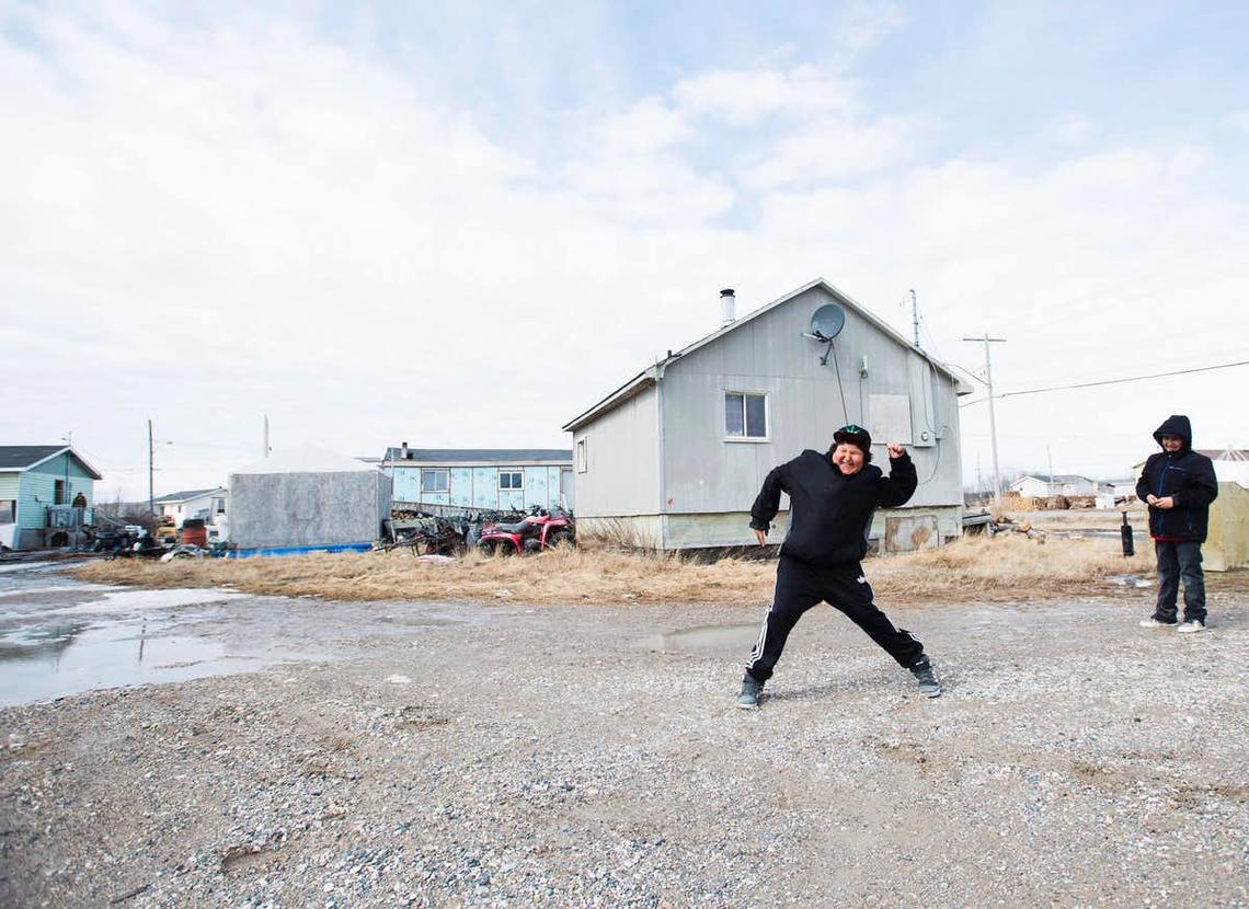Teenage boys throw rocks in the Attawapiskat First Nation in northern Ontario, in April 2016.