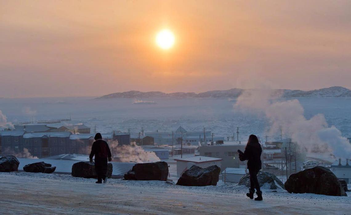 People walk along a path in Iqaluit, Nunavut in December 2014.
