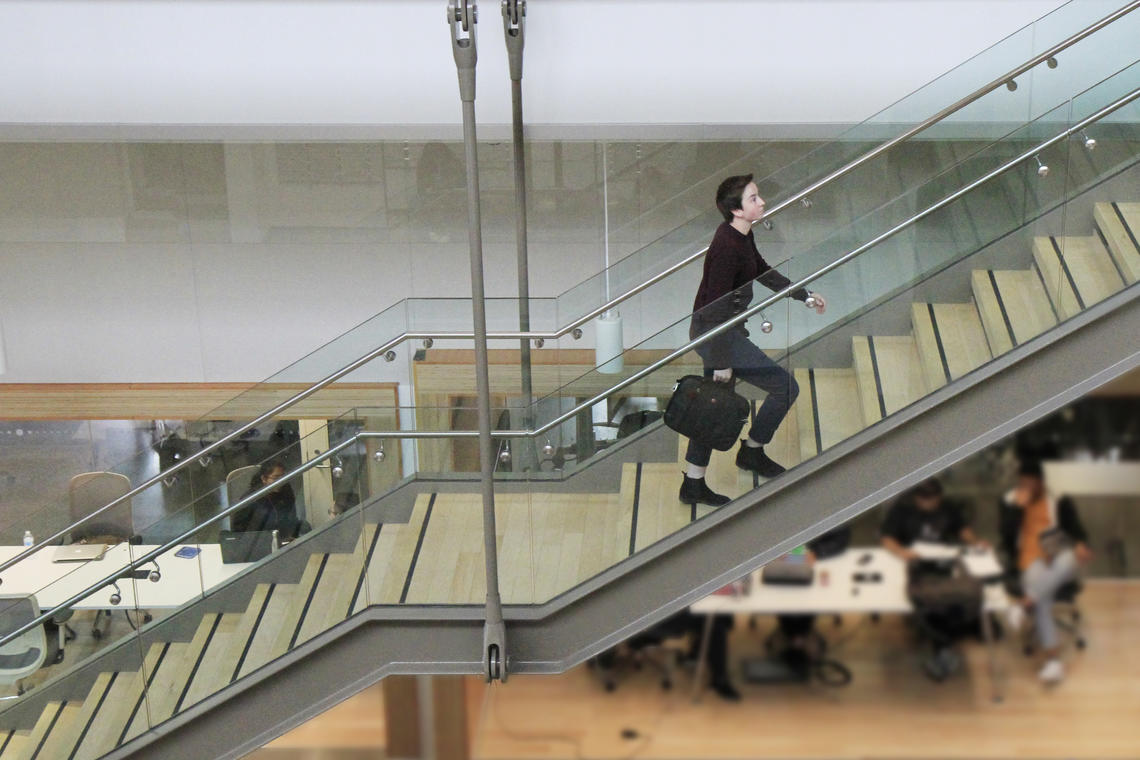 Person ascends stairs in the Taylor Institute for Teaching and Learning