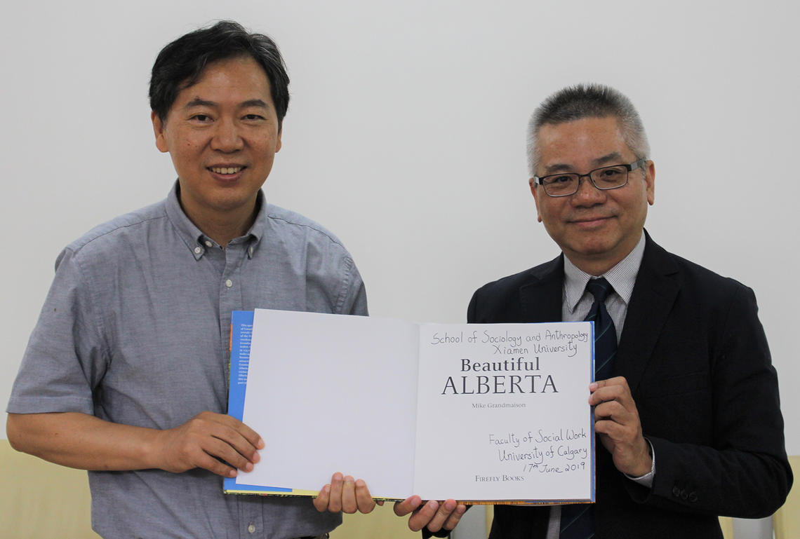 Two men and book about Alberta