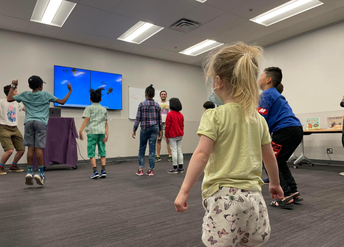 A group of children get up and move around like insects