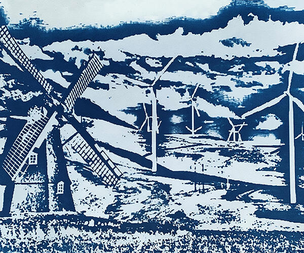 Cyanotype image. A field of blue and white wind turbines with a windmill in the foreground.