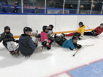 Adapted camp participants playing hockey