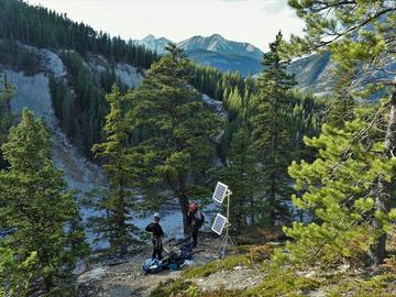 Nicolau Roldan and Ives prepare to descend the cliff, next to solar panels which power their equipment and data loggers.