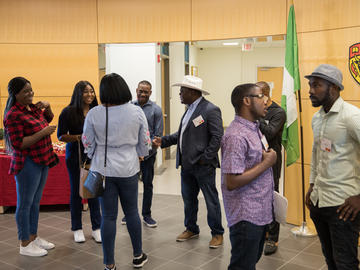 Graduate students, faculty and members of the Nigerian High Commission office mingle before the Stampede breakfast.