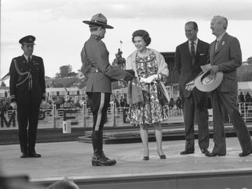 Queen Elizabeth meeting Royal Canadian Mounted Police officer at afternoon grandstand performance, Calgary, Alberta