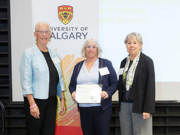 Dr. Christine Walsh (Faculty of Social Work), centre, receives the McCaig-Killam Teaching Award from Killam Trustee Brendan Eaton, left, and Interim Provost Penny Werthner, right