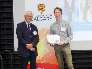 Owen Paetkau (Physics and Astronomy), right, receives a First Year Izaak Walton Killam Memorial Scholarship from Killam Trustee Kevin Lynch, left