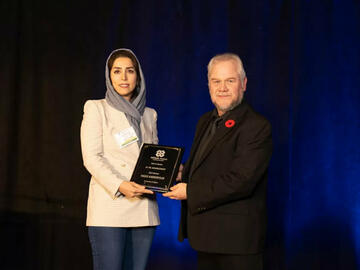 Dr. Hadis Karimipour (left) accepting the award for Best in Sector: AI / ML Advancement