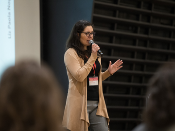 Liz stands on stage pitching