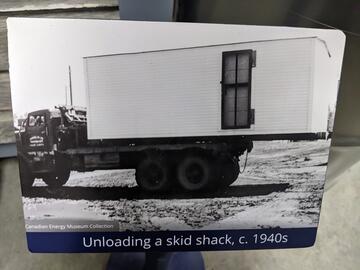 A photo of a black and white picture from the 1940's of a skid shack being moved