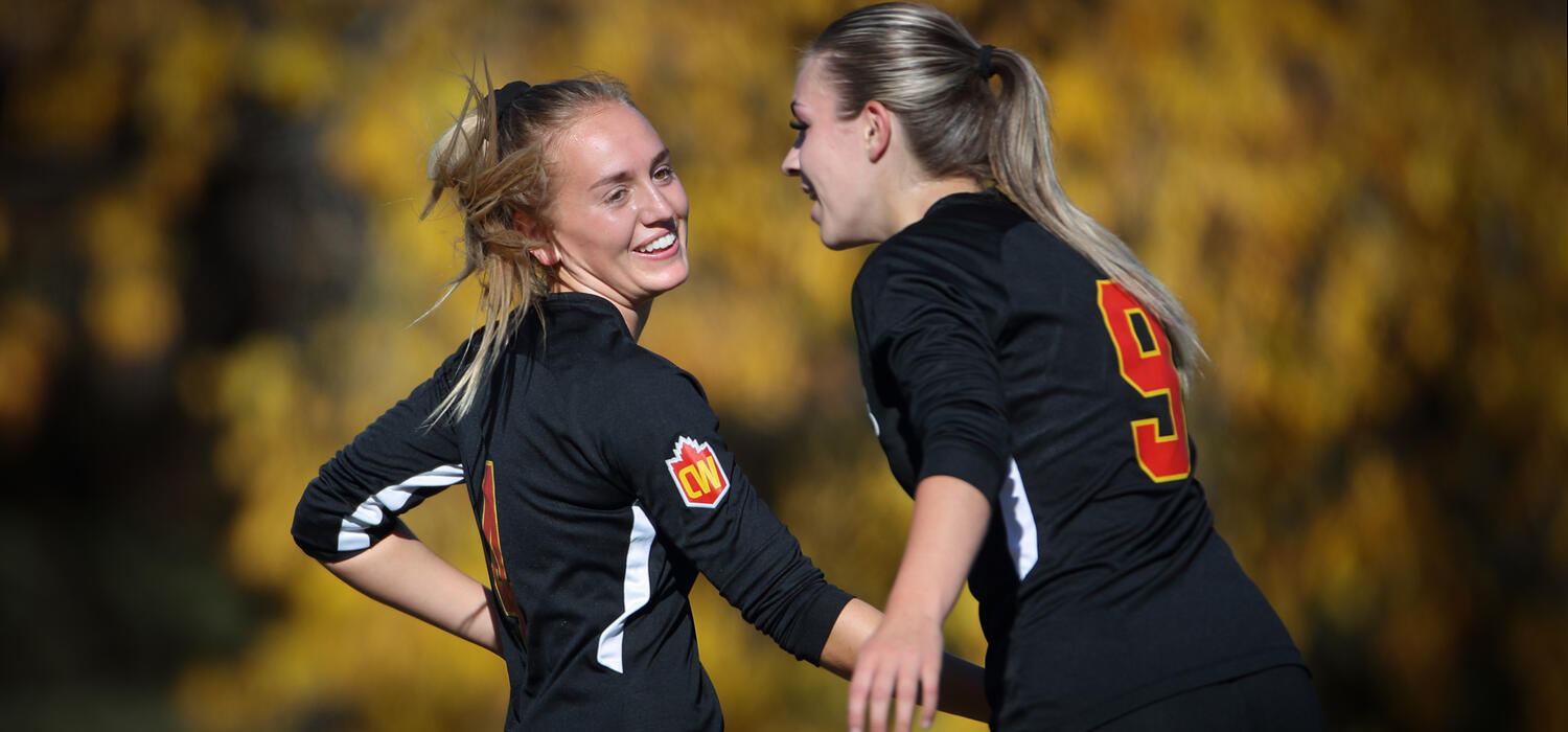 Rachel Barlow celebrates with teammate Alison Pedersen during a game against Thompson Rivers University. 