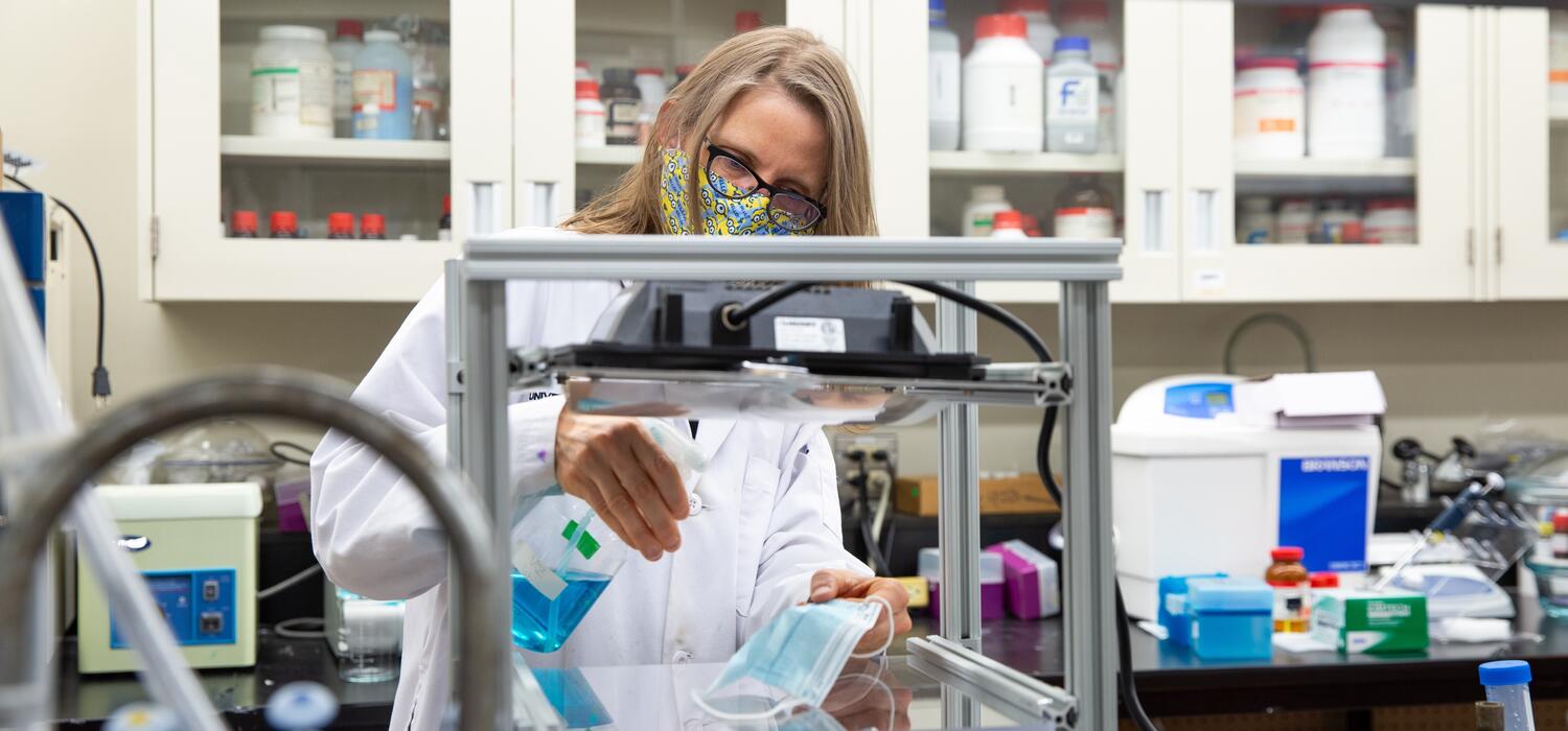 Belinda Heyne spraying a mask with her microbe-killing spray