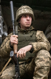 A Ukrainian soldier sit in the trench on the line of separation from pro-Russian rebels in eastern Ukraine in January 2022.