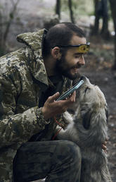 A Ukrainian soldier plays with a dog as he has a rest in the freed territory in the Kharkiv region of Ukraine on Sept. 12, 2022