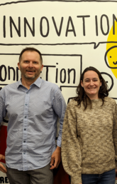 Adam Pidlisecky, Paula Berton and Jagos Radovic stand together and smile in front of a wall that says innovation