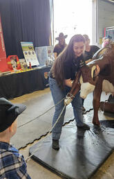 Gabrielle Jensen gets help from some local children in "birthing a calf," while at the UCVM Stampede Booth