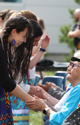 Elder Florance Kelly shakes hand with UCalgary student, Kiara Johnson from Maskwacis.