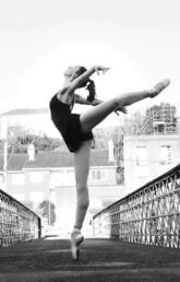 A woman dances on a bridge