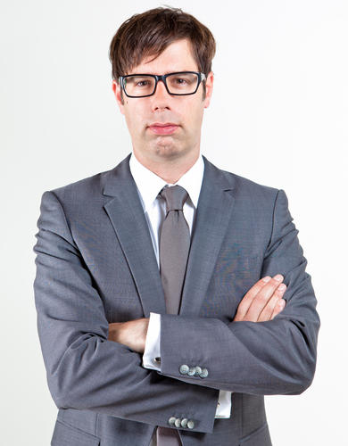 Man with glasses in grey suit with arms crossed