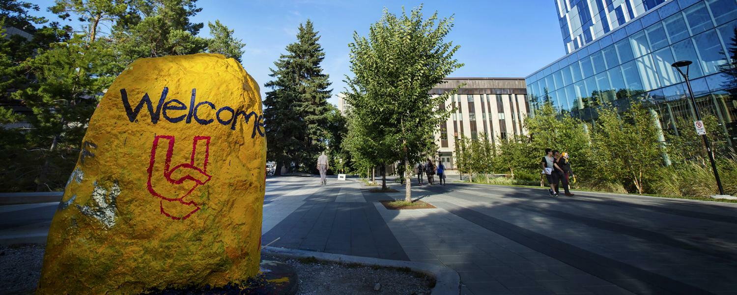 The rock is painted in UCalgary gold with welcome UC on it