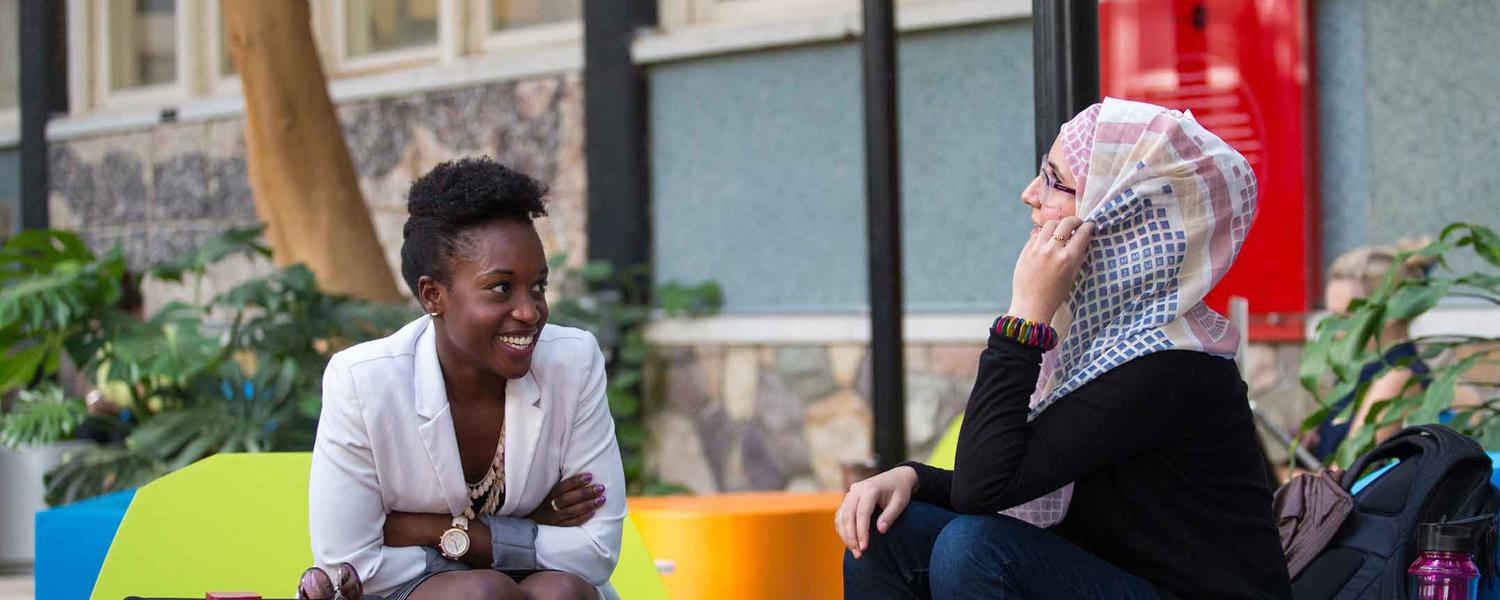 Two students chat in the atrium