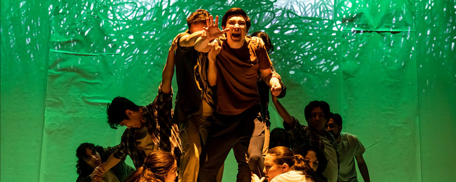 Students performing in front of a green background