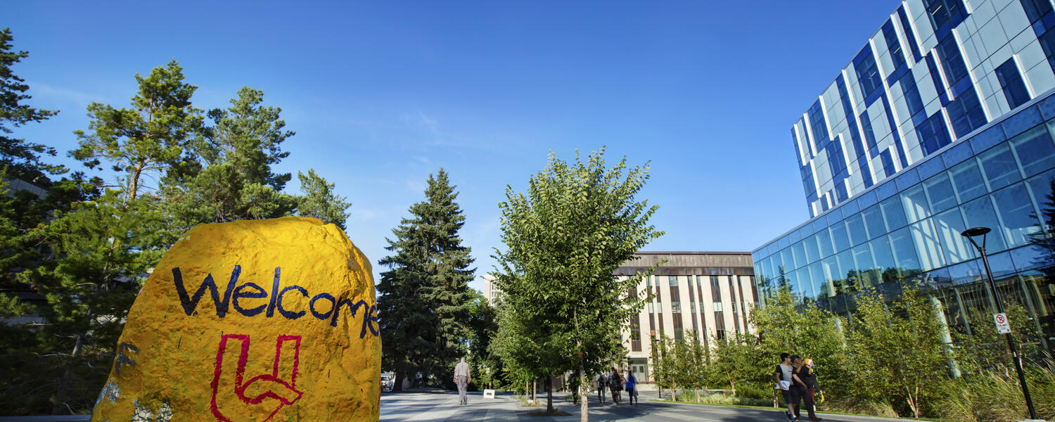 The rock is painted in UCalgary gold with welcome UC on it