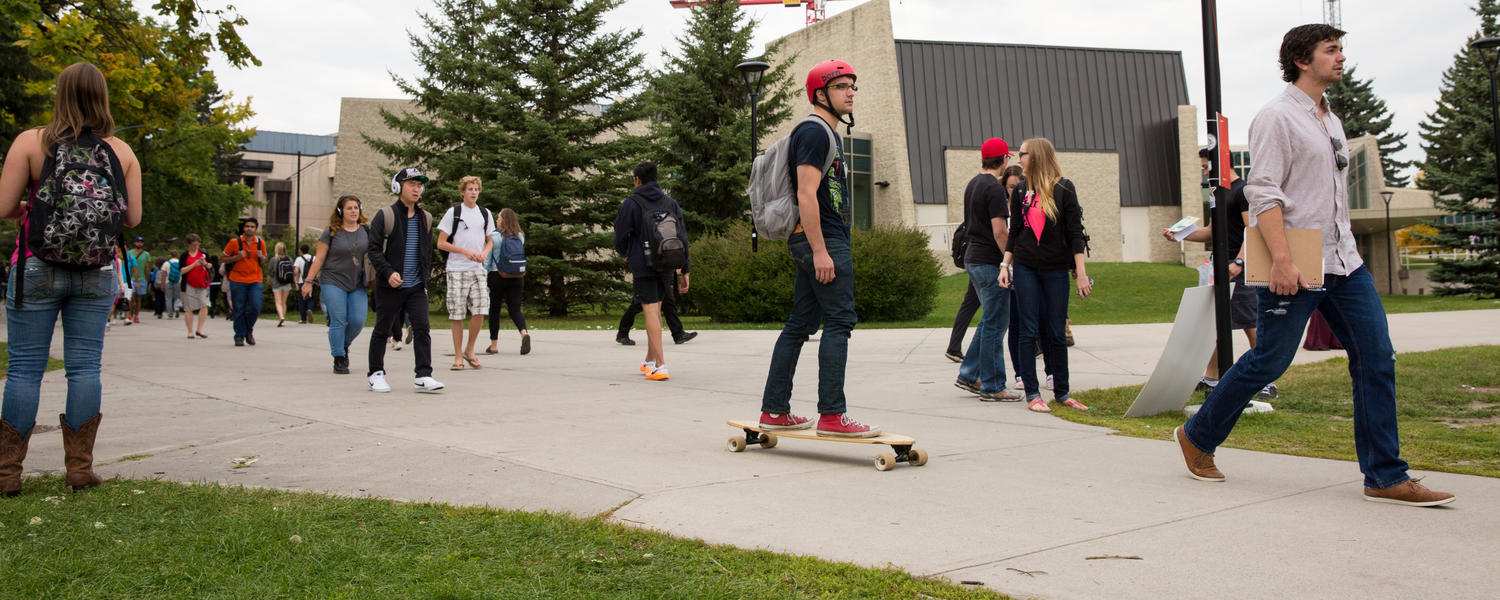 Students walk and skateboard on campus