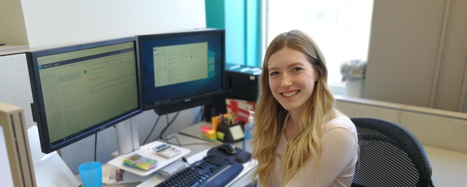 A co-op student poses at her desk
