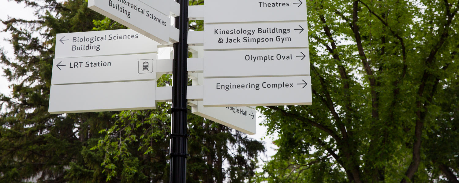 A signpost on campus with different signs pointing to various buildings