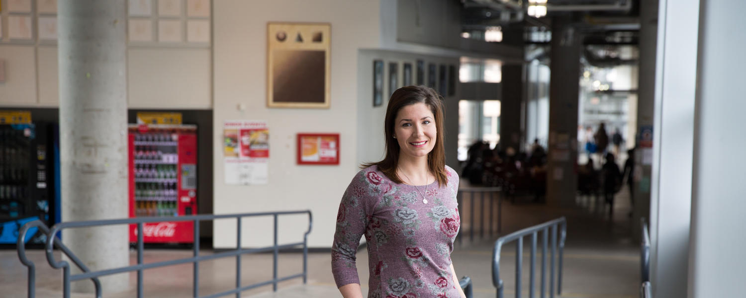 Geography Researcher Victoria Fast stands in the walkway towards ICT