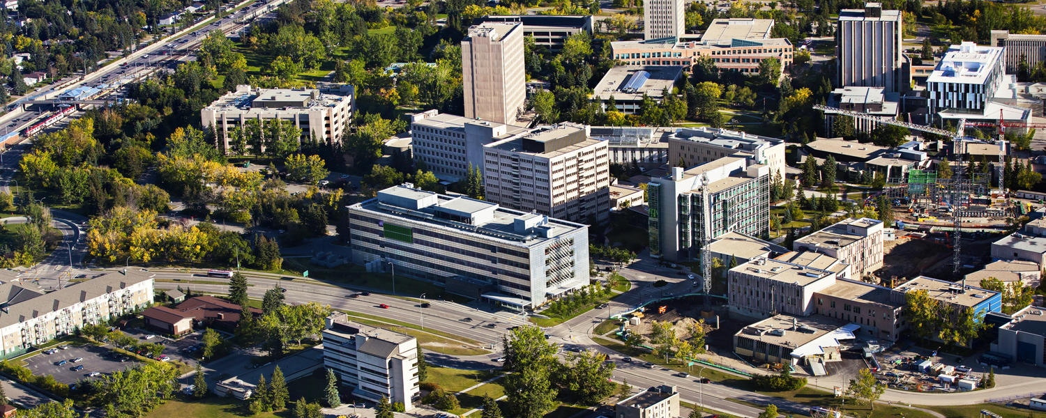 A wide aerial shot of the University campus with mountains visible in the background