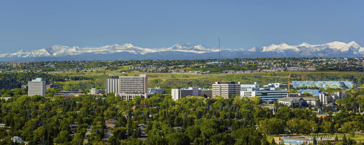 A wide aerial shot of the University campus with mountains visible in the background