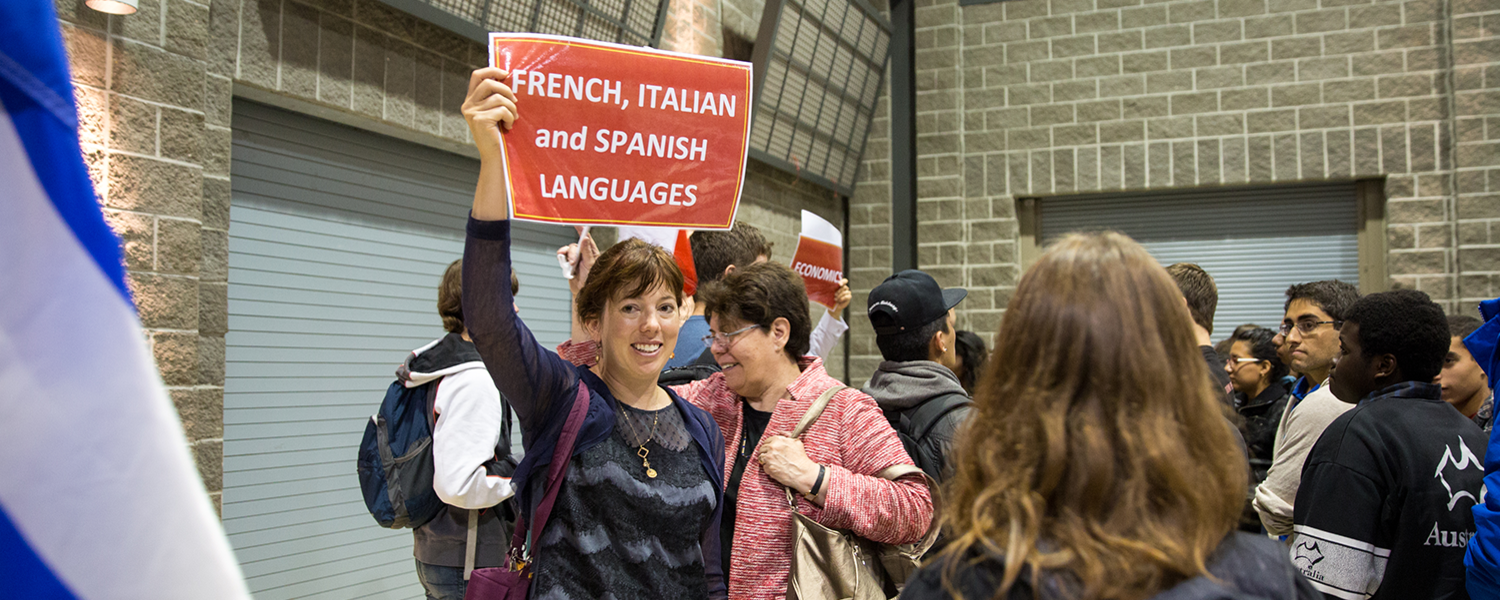 Image from Faculty Orientation. Person holds up sign that reads French Italian Spanish Languages