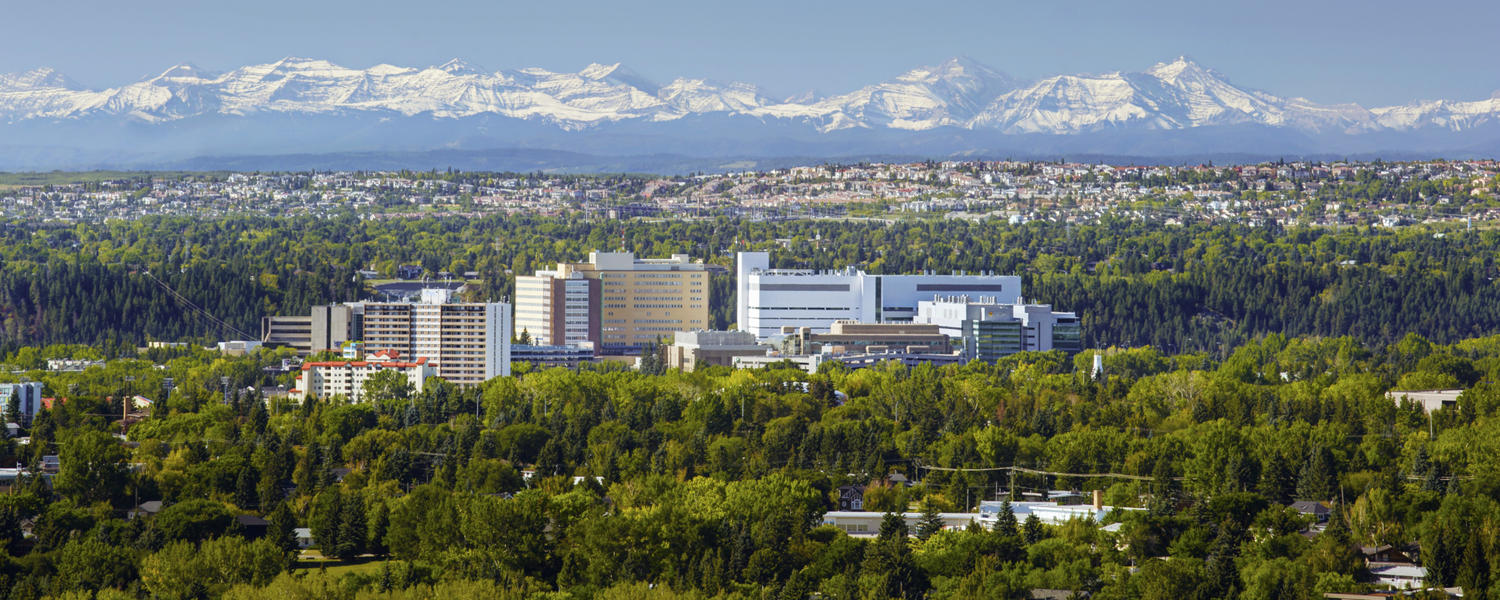 Aerial photo of Calgary with mountains in the background