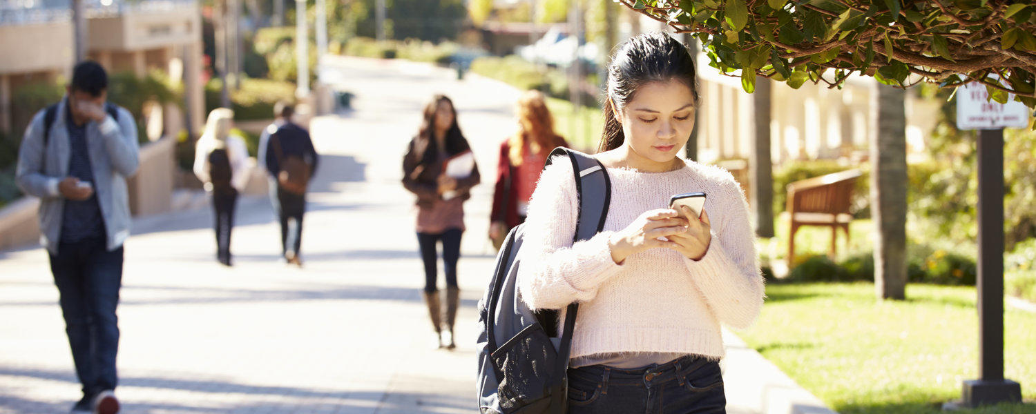 stock photo: students walk on campus in the summer