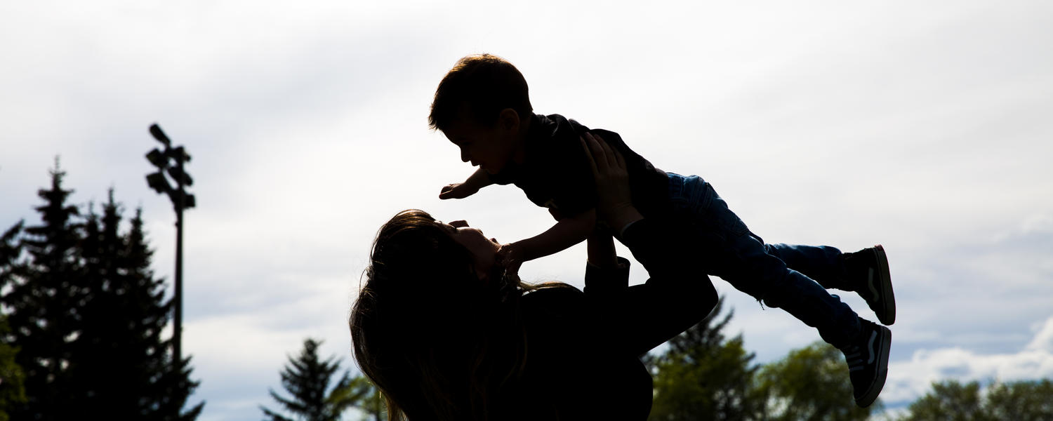 Woman holding child up in the air