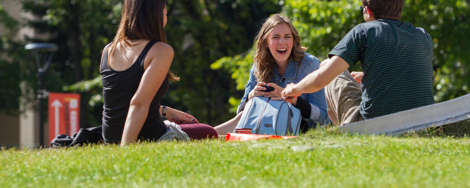 Students hanging out on a campus field
