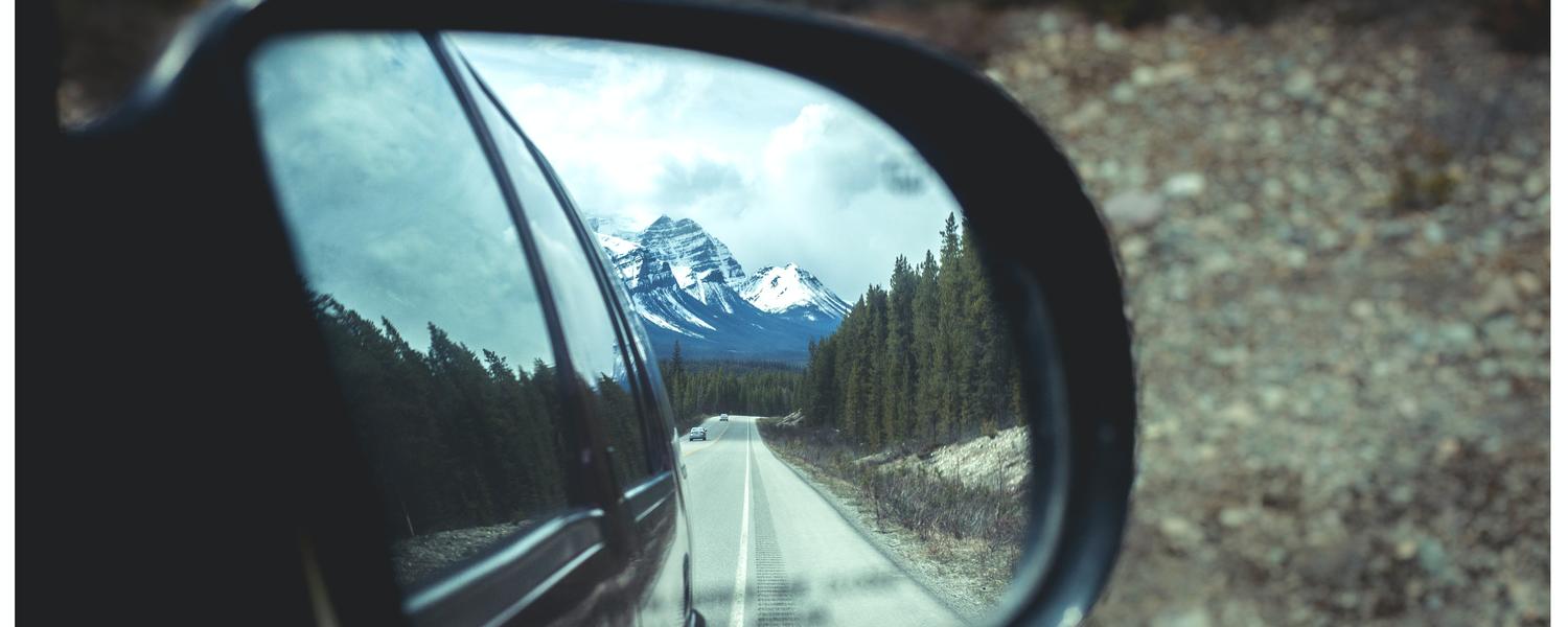 mountain in the rear view mirror of a car 