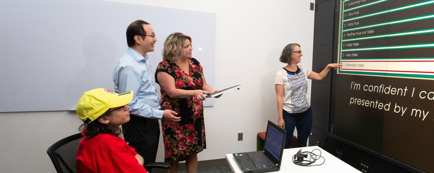 Dr. Meadow Schroeder and Dr. Richard Zhaore standing in front of a screen