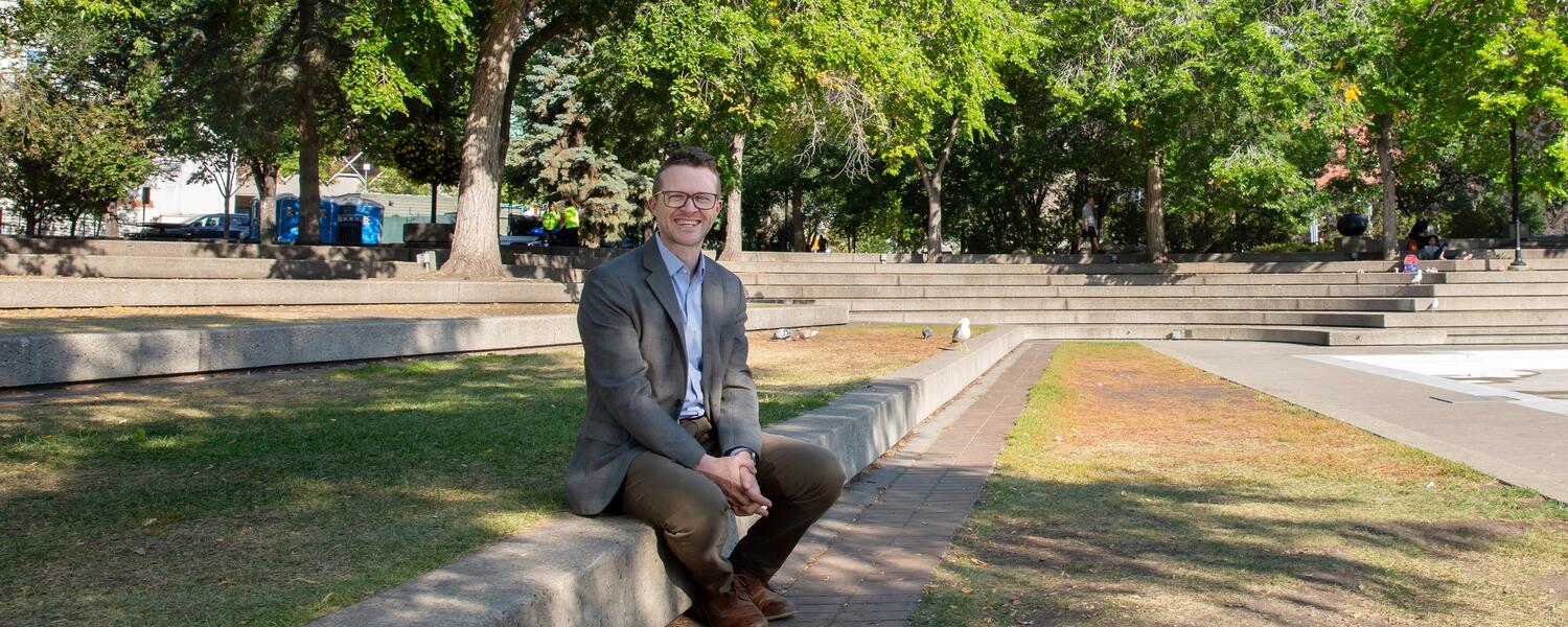 Jack-Lucas sitting on a bench with trees in the background