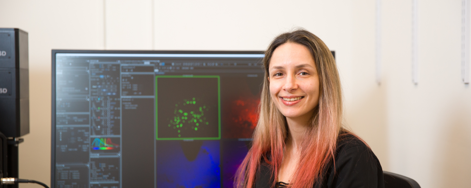 Dr. Derya Sargin, Assistant Professor in the Department of Psychology, sits in front of a computer showing graphs related to her research on brains and stress