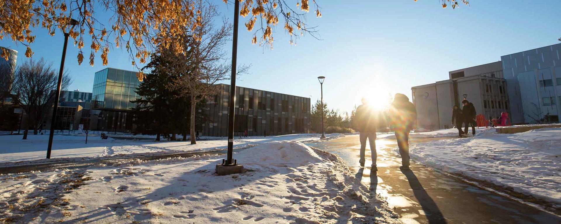 Students walk across a snow-covered campus