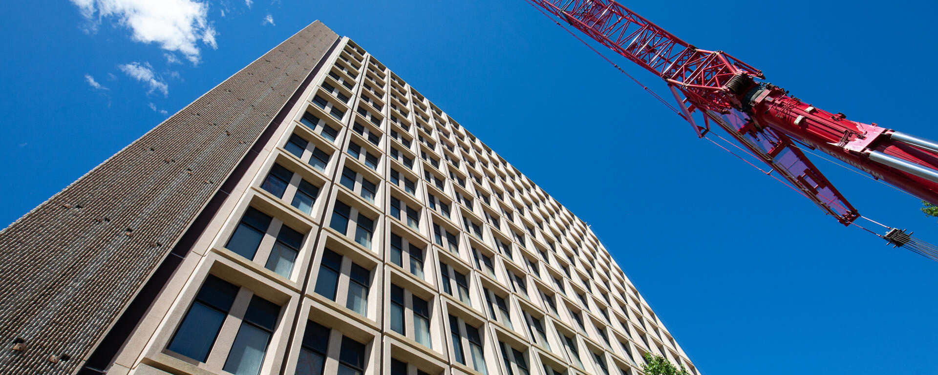 Looking up at the Social Sciences Tower with a crane in the sky
